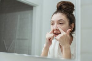 young woman washing her face in the bathroom - skin care beauty