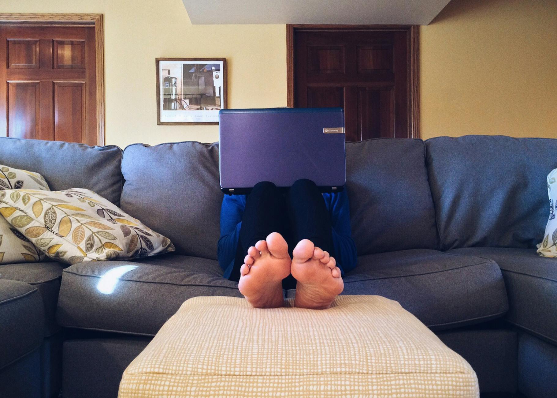 person sitting on couch while using laptop computer